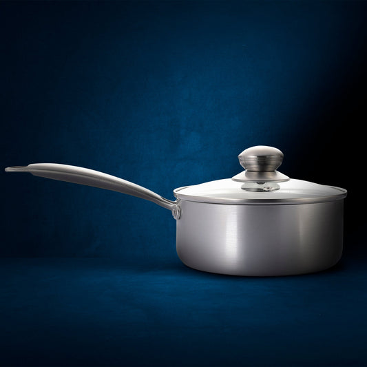 Stainless steel saucepan with glass lid on a white background