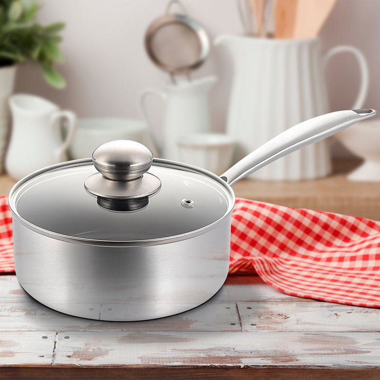 Silver saucepan with lid on a wooden surface with a red and white checkered cloth