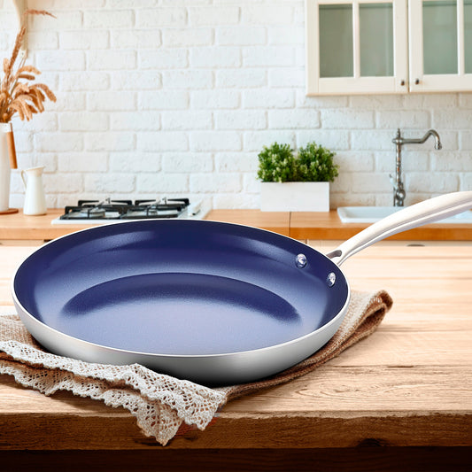 Stainless steel frying pan with a blue non-stick coating on a white background