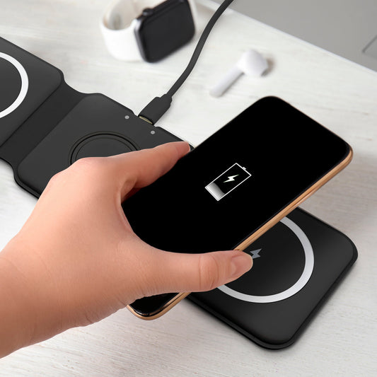 Black wireless charging pad with three circular pads on a white background
