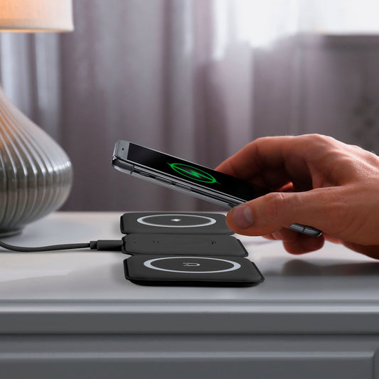 Black wireless charging pad with three circular pads on a white background