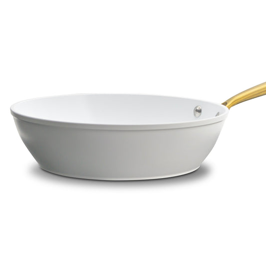 White frying pan with a gold handle on a white background