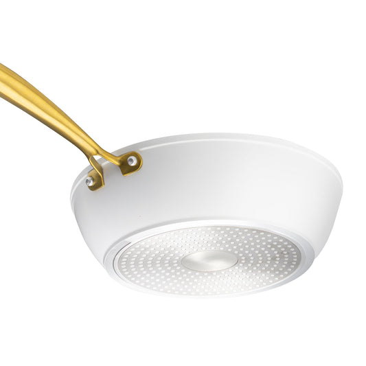 White frying pan with a gold handle on a white background