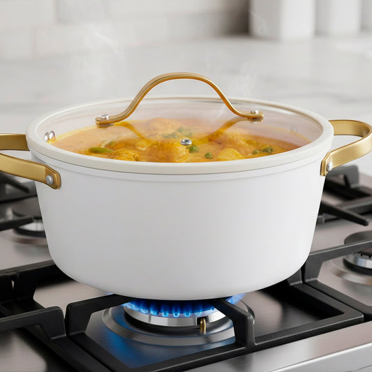 White ceramic pot with gold handles on a white background