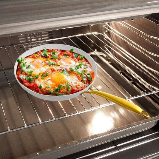 White wok with a gold handle on a white background