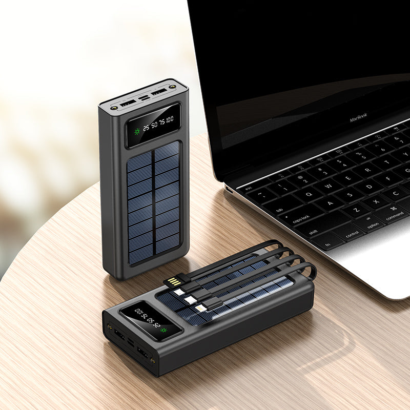 Solar-powered power bank and adapter on a wooden surface with a laptop in the background.
