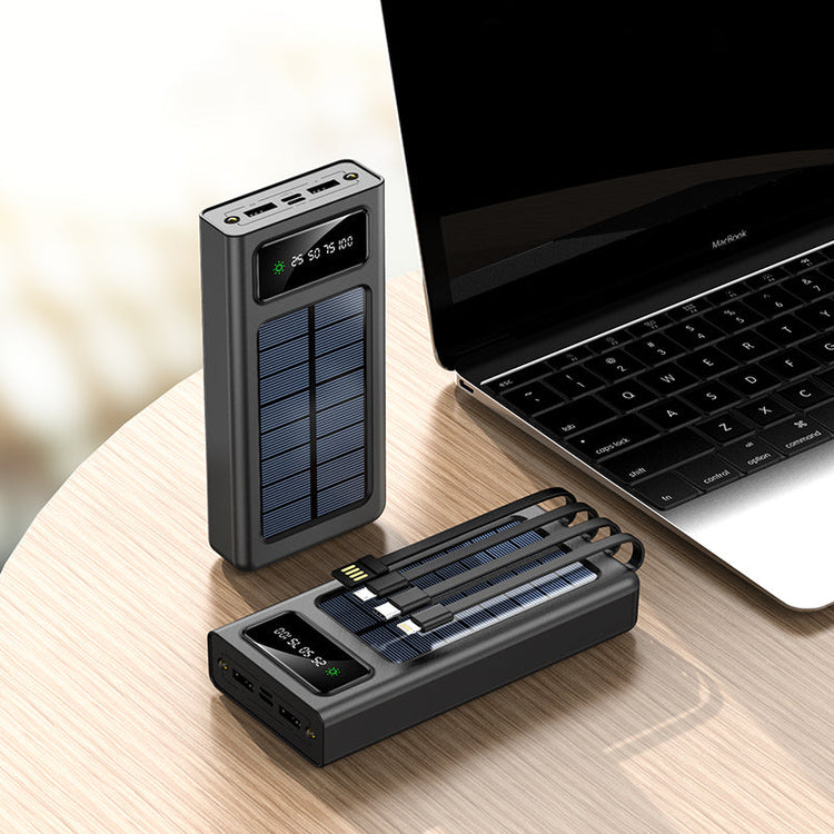 Solar-powered power bank and adapter on a wooden surface with a laptop in the background.