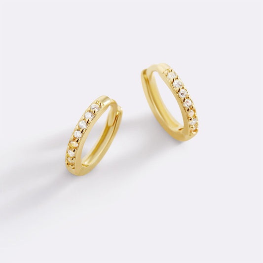 Gold hoop earrings with small diamonds on a white background