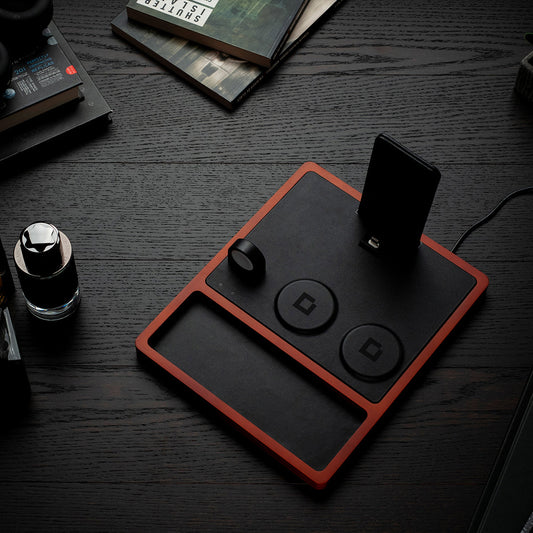 A 4-in-1 MagSafe oak wireless charger with a black and brown color scheme, featuring a section for charging an Apple Watch, a smartphone, and additional wireless charging pads.