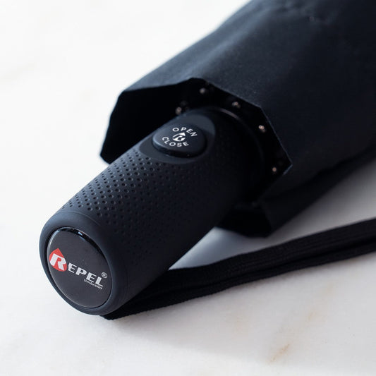 Black umbrella with 'Repel' branding and 'Lifetime Replacement' promise on a white background