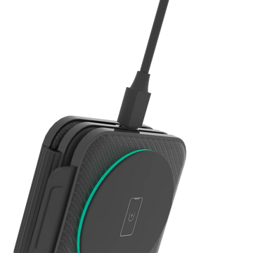 A black wireless charging pad with a built-in magnetic phone stand and nightlight feature.