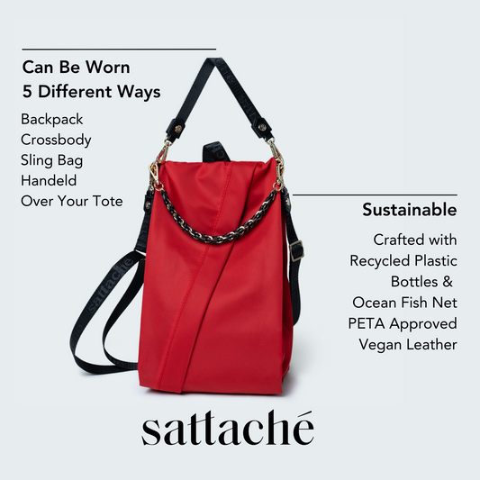 Red bag with black straps and chain detail on a light gray background