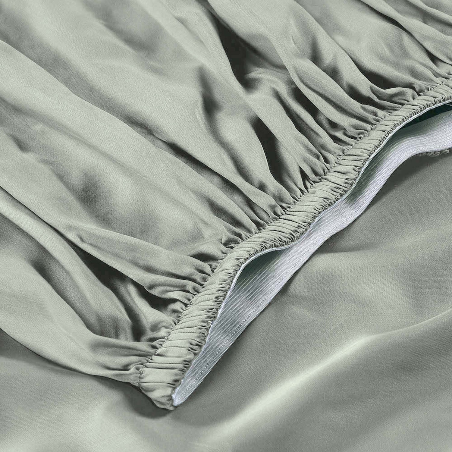 Close-up of a fitted sheet on a bed with a visible brand label.