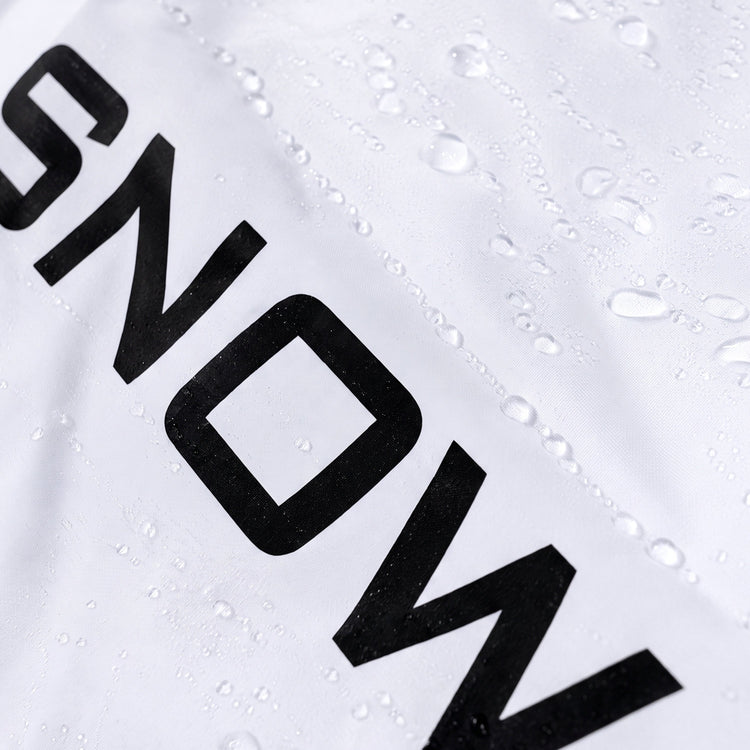 Close-up of a white athletic garment with bold black lettering and water droplets on the surface.