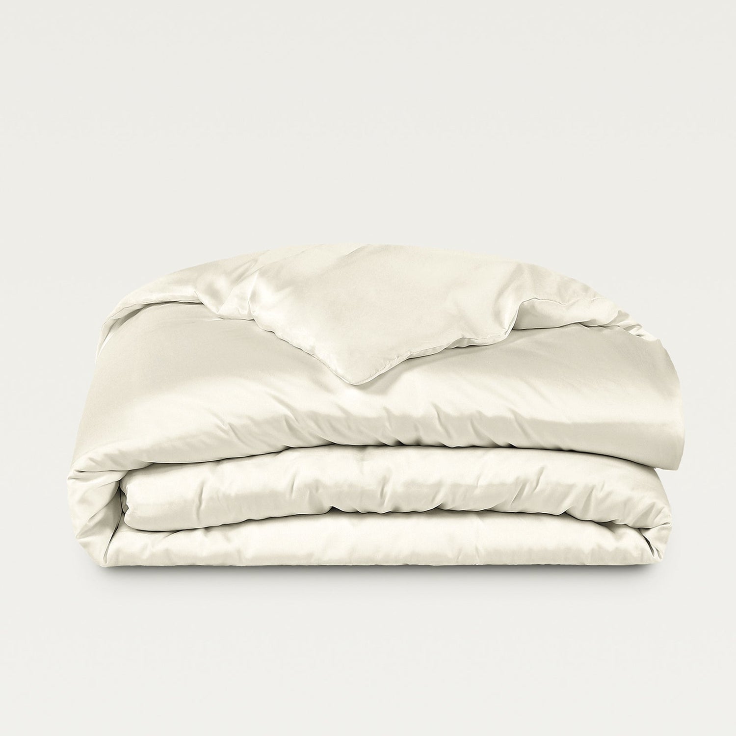 Folded beige comforter on a light gray background