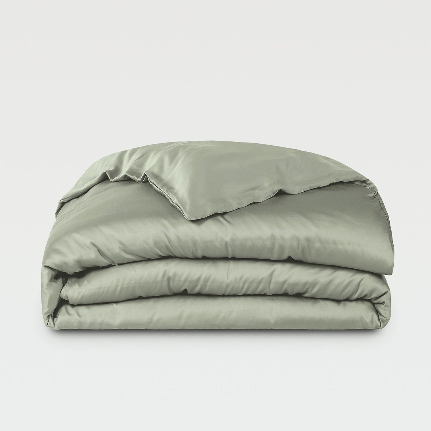 Folded green comforter on a white background