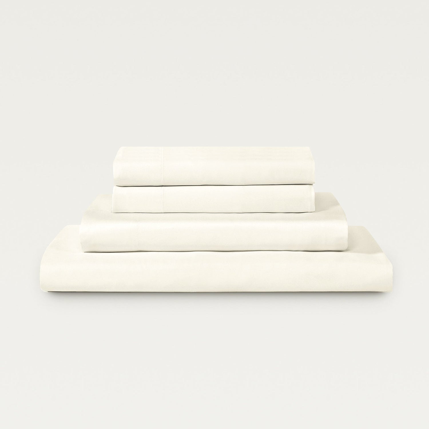 Set of white bed sheets stacked on a light gray background