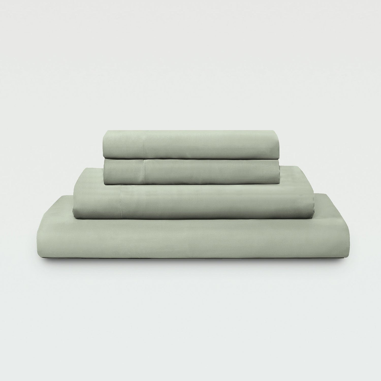 Set of green bed sheets and pillowcases on a white background