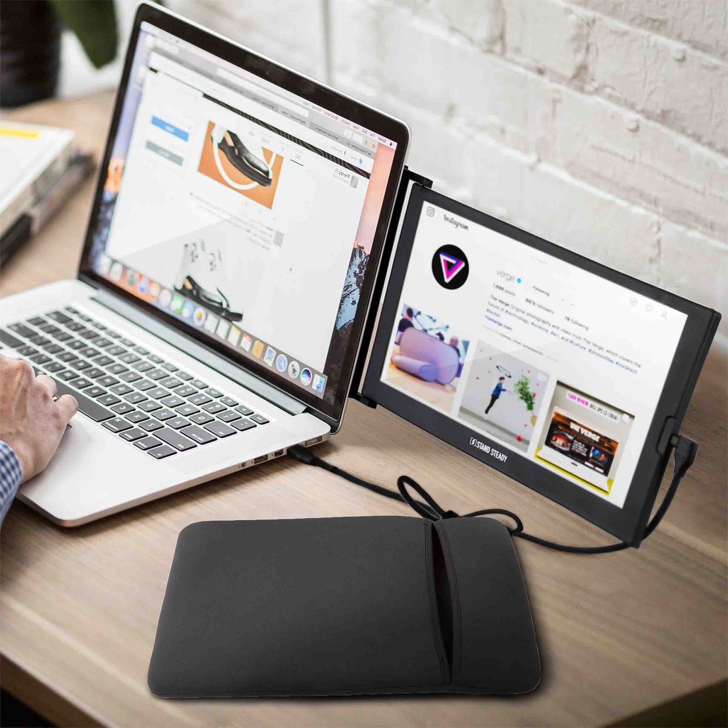 Laptop and tablet setup on a desk with a wrist rest, showing a person using the laptop.