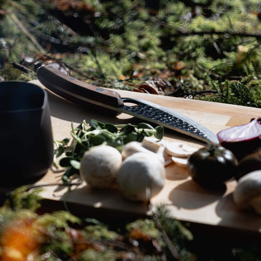 A Kyodai Utility Chef Knife and fresh mushrooms on a cutting board, ready for a delicious culinary adventure!