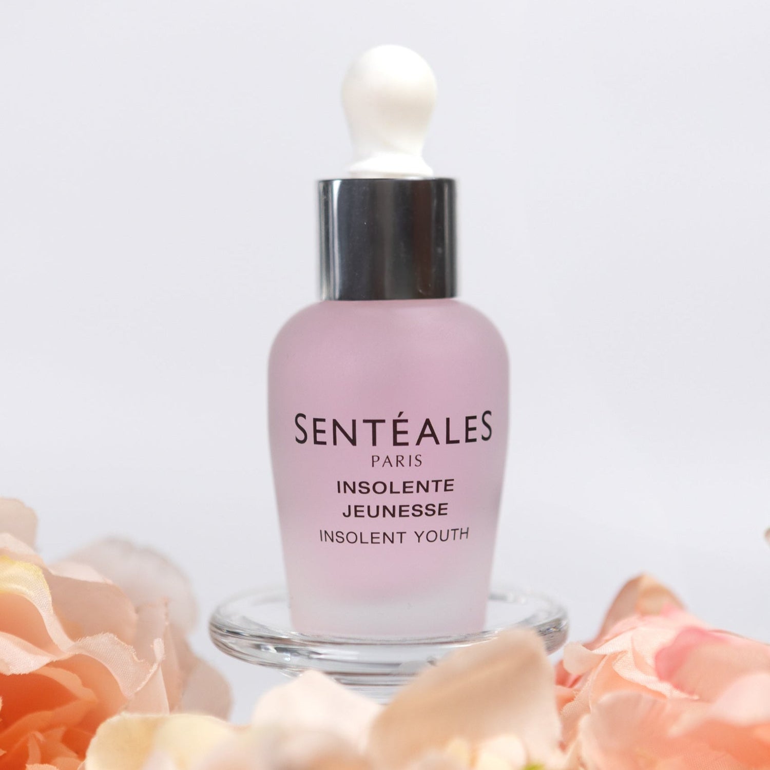 Sentéales skincare bottle with flowers on a white background
