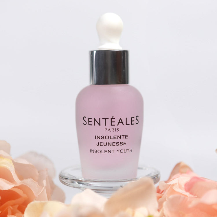 Sentéales skincare bottle with flowers on a white background