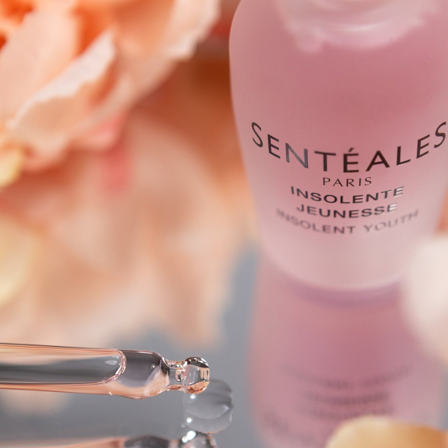 Sentéales skincare product with dropper and floral background