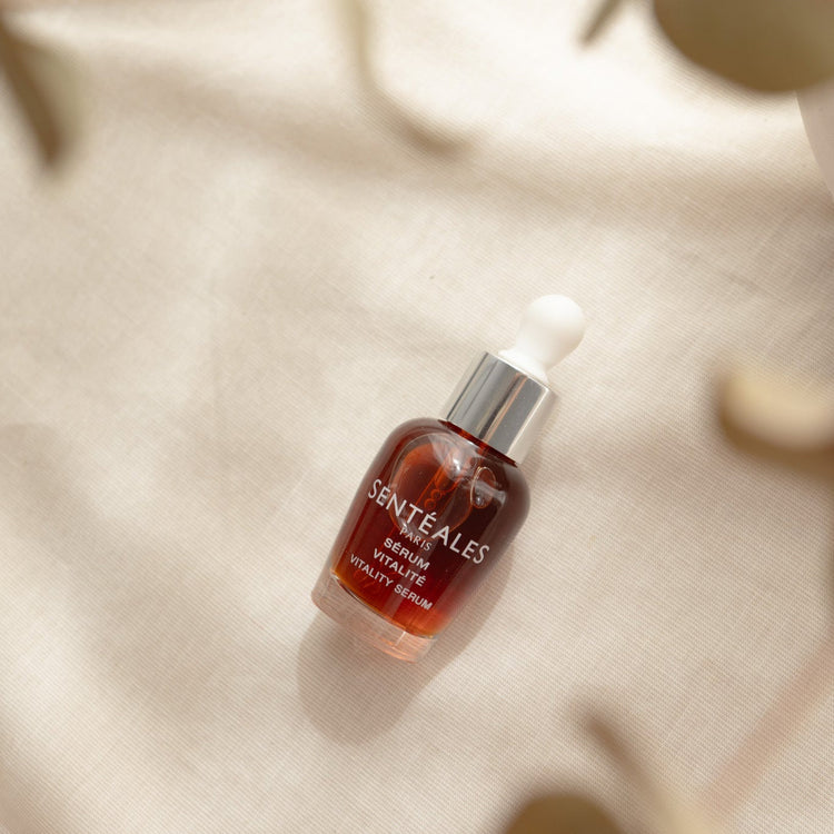 Skincare serum bottle on a beige surface with natural light