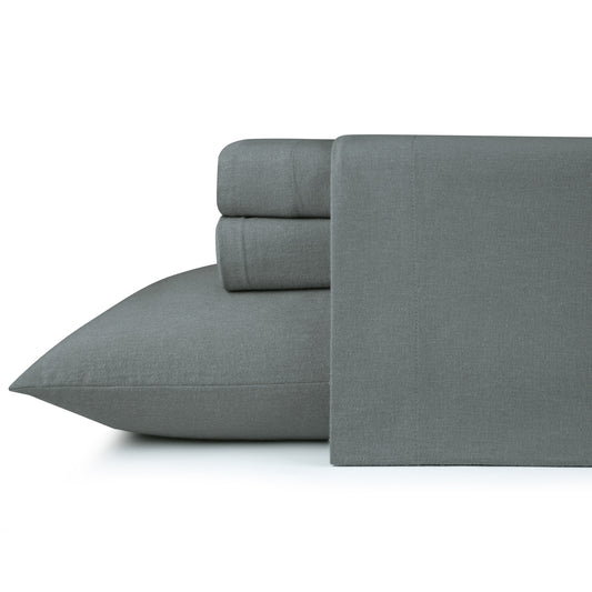 Gray bed sheets on a wooden bed with a wooden nightstand and decor items.