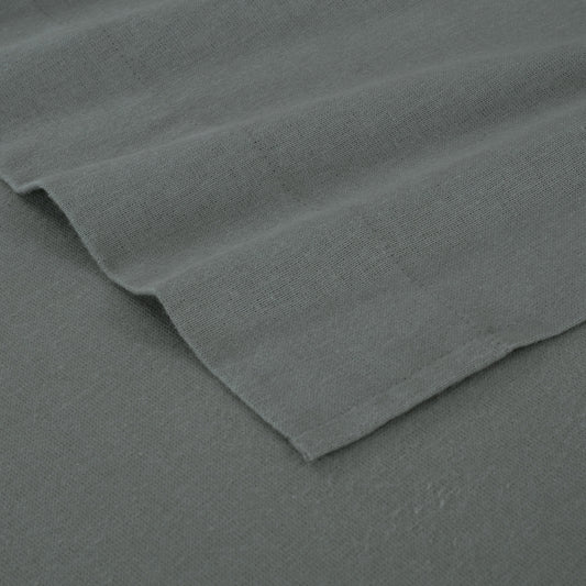 Gray bed sheets on a wooden bed with a wooden nightstand and decor items.