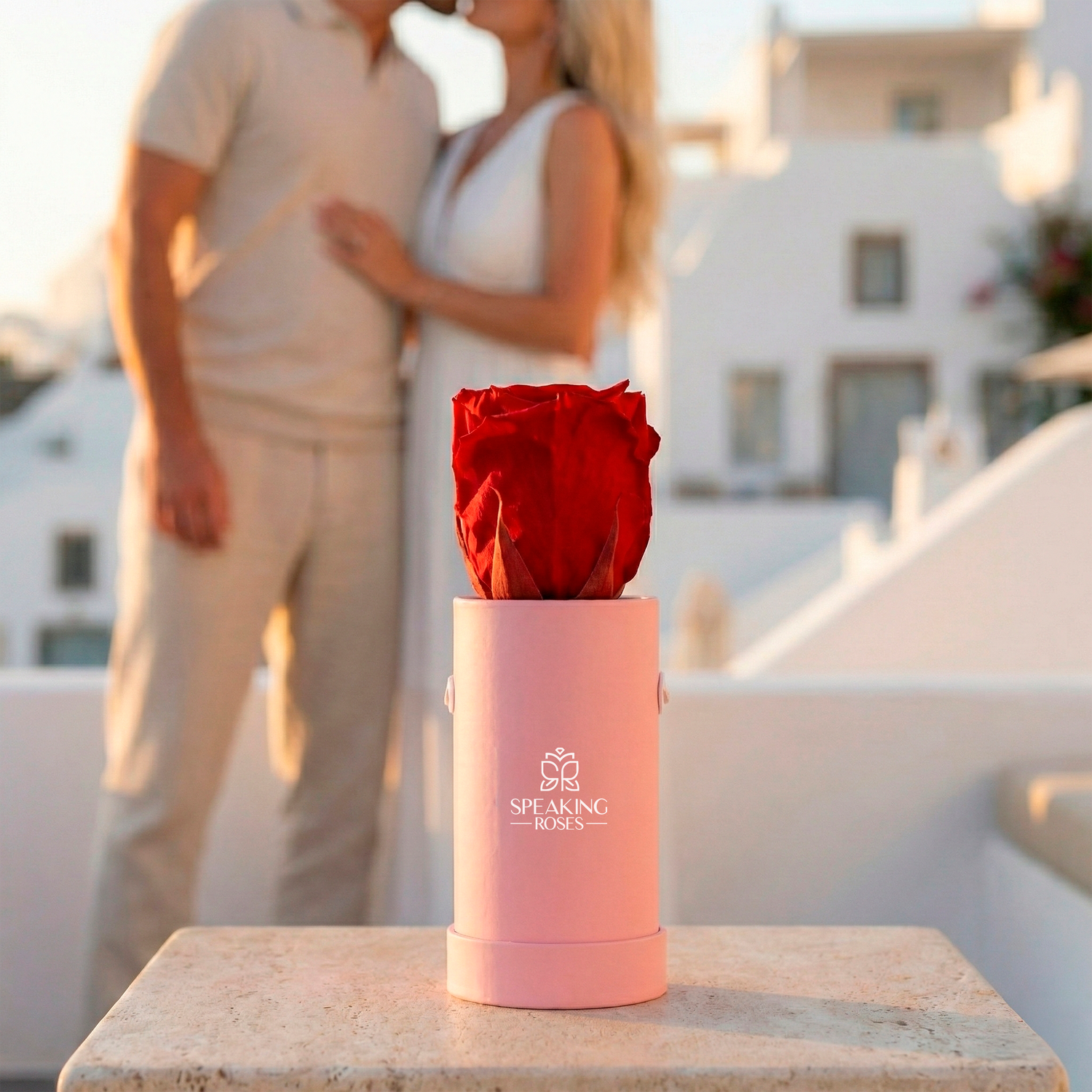Pink container with a red rose on a ledge with a couple in the background