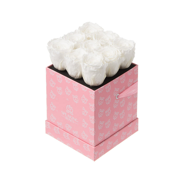 White decorative item in a pink box with floral patterns on a white background