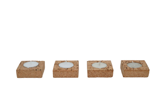 Four cork coasters with embedded candles on a white background
