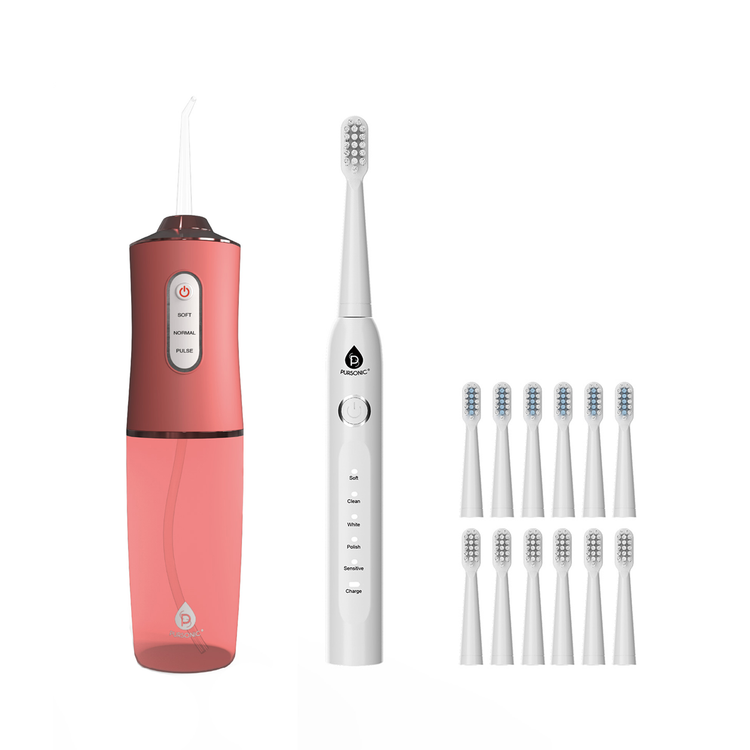 Pink and white electric toothbrush with multiple brush heads on a white background