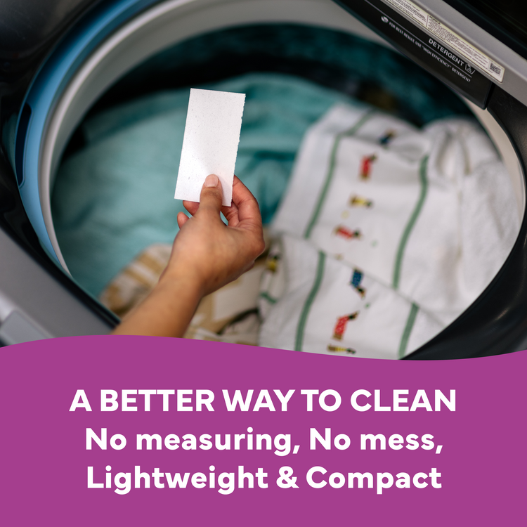 Hand holding a white card in front of a washing machine with text about a better cleaning method.