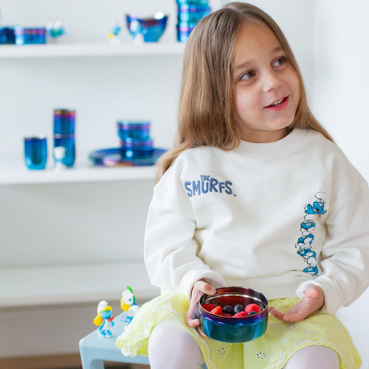 Three blue metal containers with colorful rims on a white background - each with a Smurf etched on the lid along with The Smurfs logo - Papa Smurf, Smurfette, and Classic Smurf