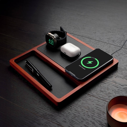 A wireless charging pad with integrated Apple Watch charger, featuring a black and oak design, with a smartphone, smartwatch, and earbuds being charged.