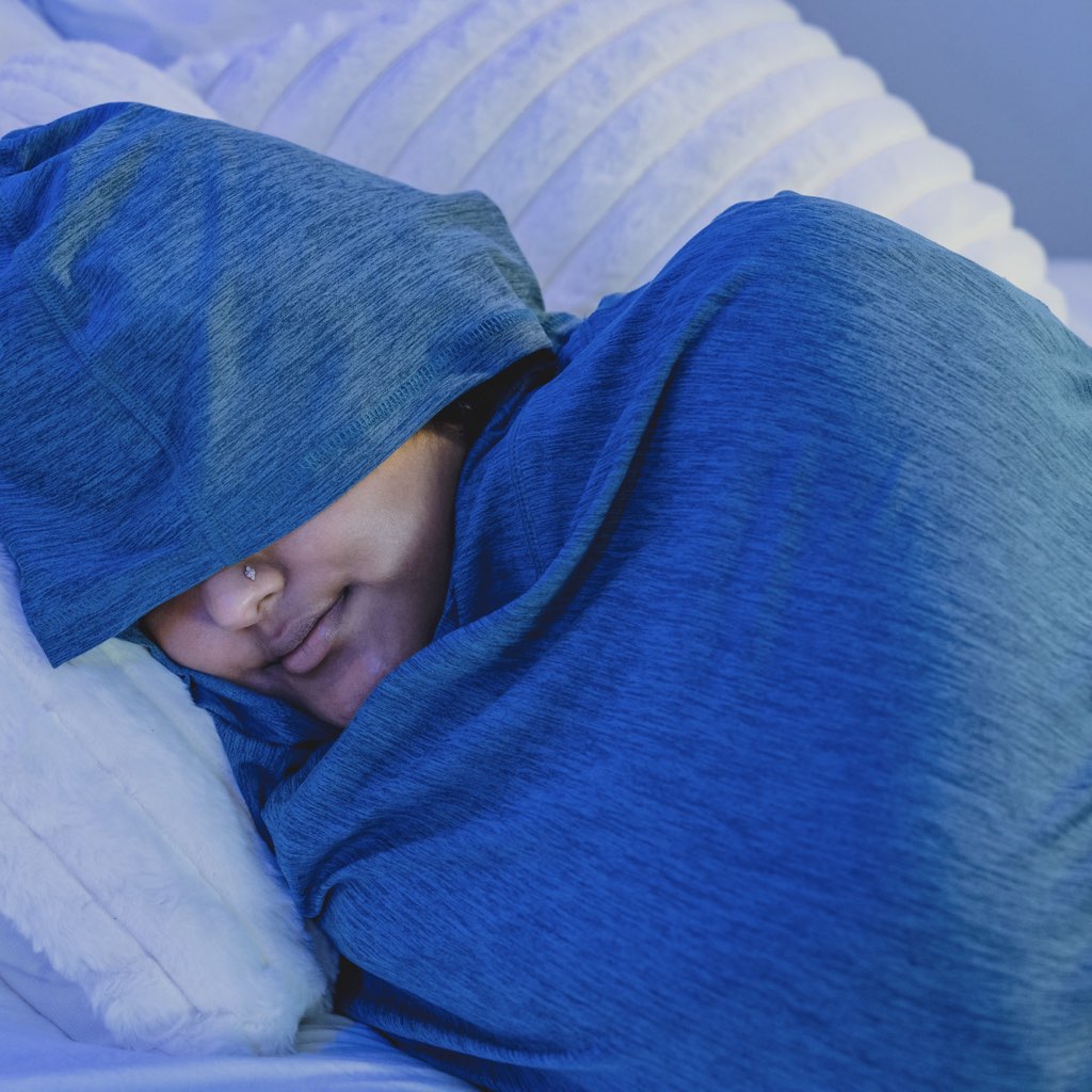 Woman in Sleep Pod Hood in bed laying down