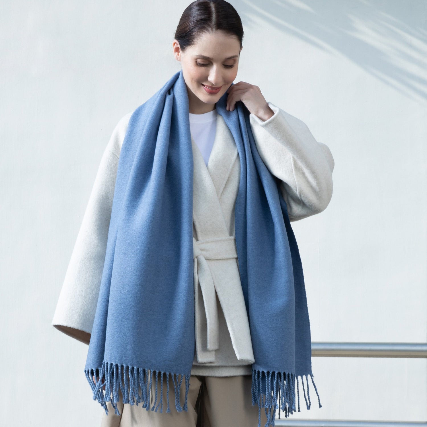 Woman wearing a blue scarf with a white background