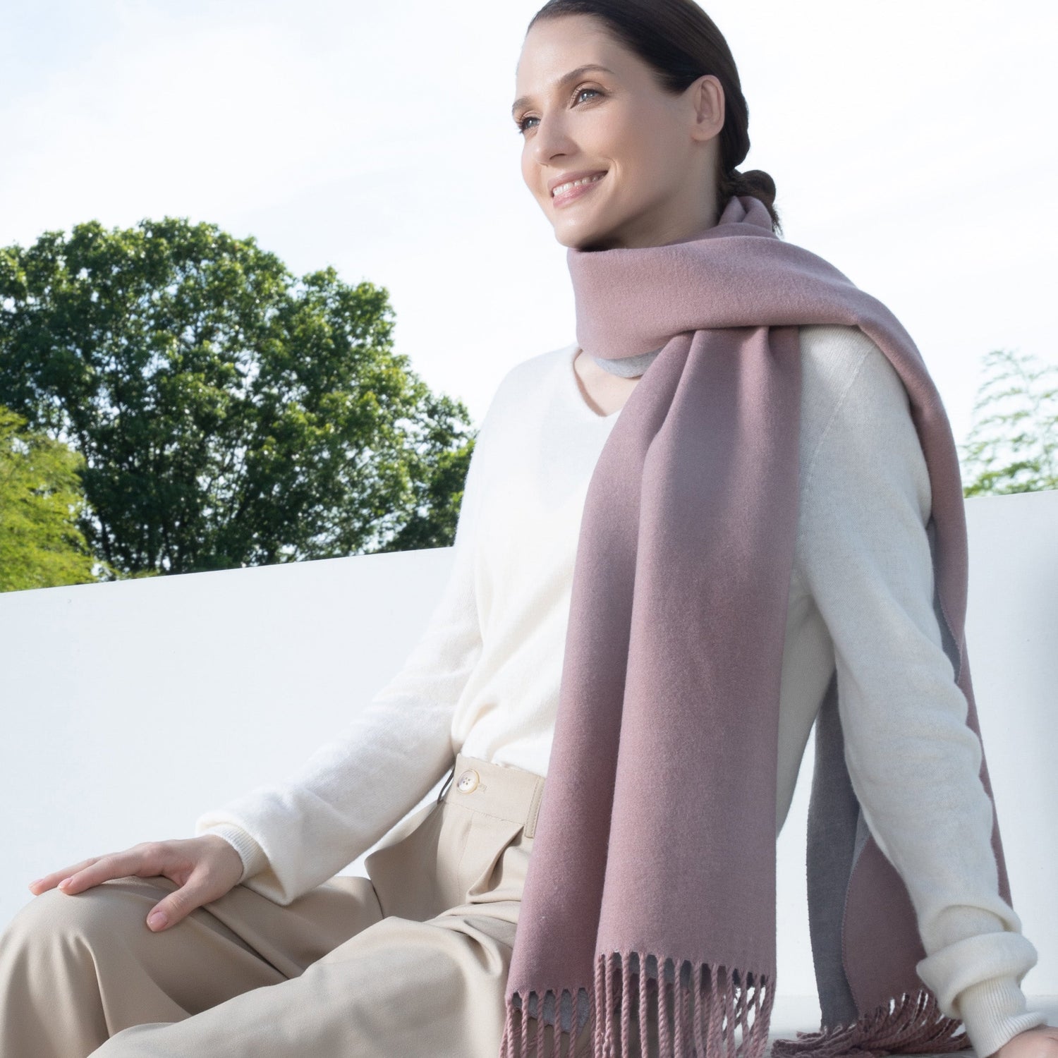 Woman wearing a pink scarf outdoors with trees in the background