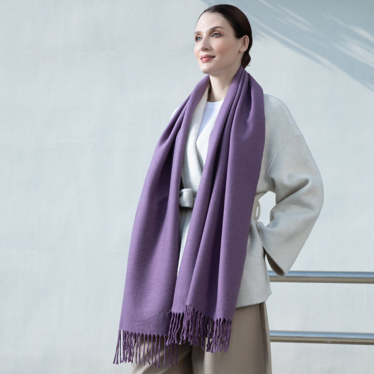 Woman wearing a purple scarf against a light background