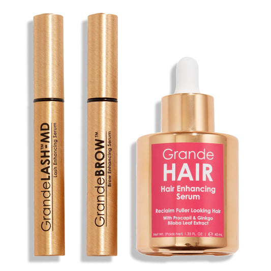 Three cosmetic products including a mascara, eyeliner, and hair serum on a white background