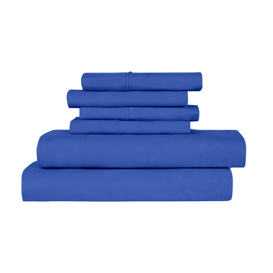 Blue bedding set on a bed in a room with large windows.
