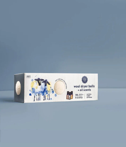 Box of wool dryer balls with oil scents on a gray background