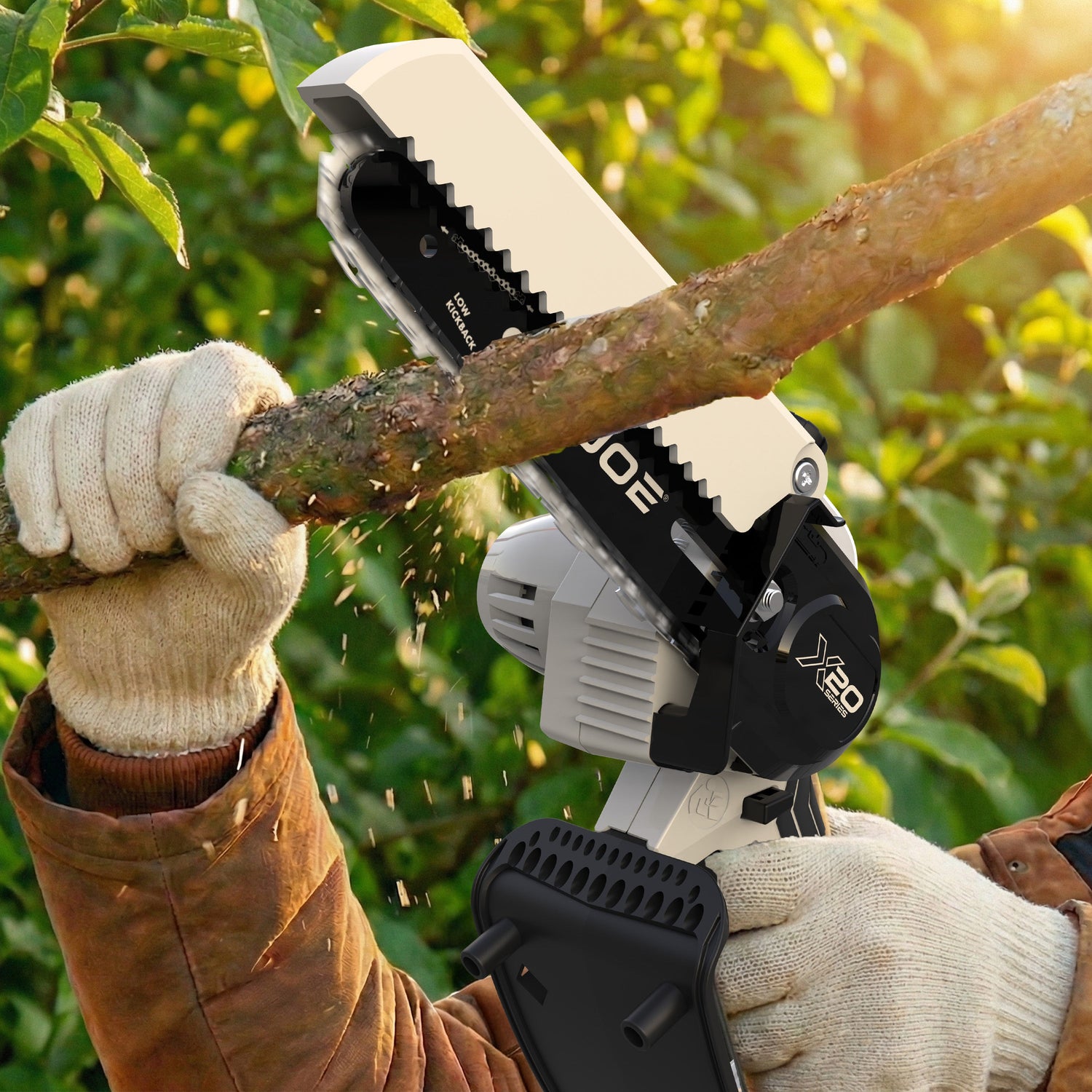 Person using a chainsaw to cut a branch with a blurred green background