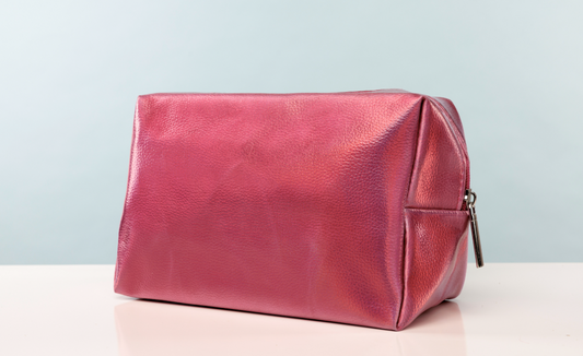 Red leather toiletry bag on a light gray background