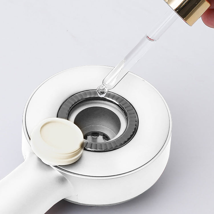 White electronic device with a clear dropper adding liquid to it on a light gray background