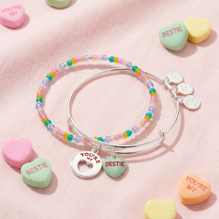 Colorful beaded bracelet with heart-shaped charms on a pink background