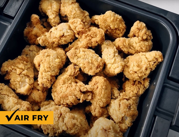 Air fried chicken pieces in a black container with 'AIR FRY' label.