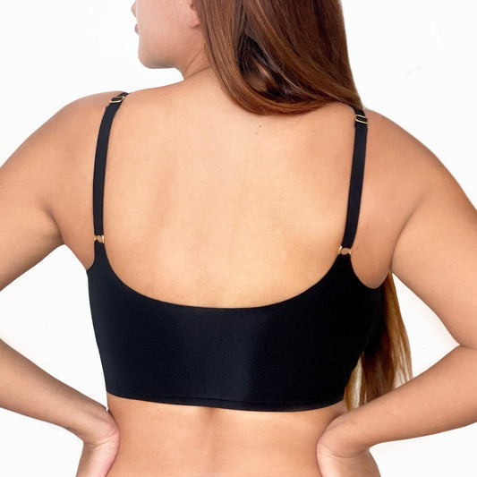 A model wears a black bra and pants against a white background. The front of the bra is displayed. 